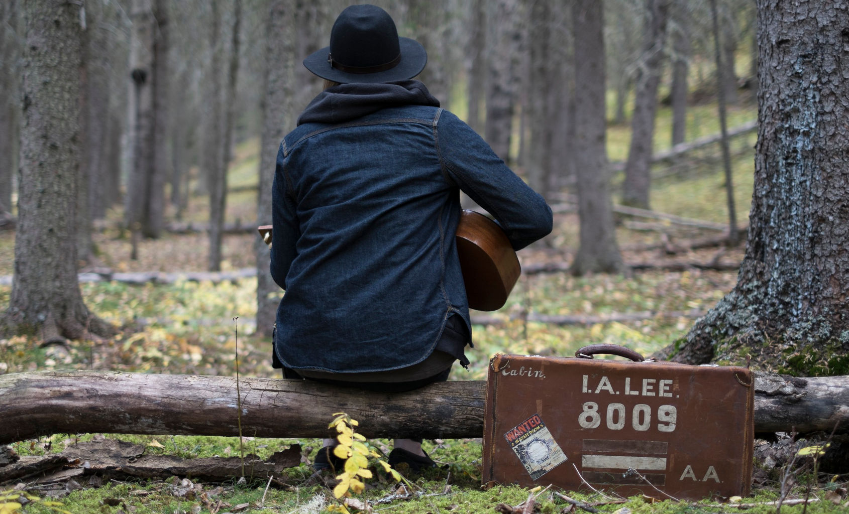 Man playing guitar in a forest